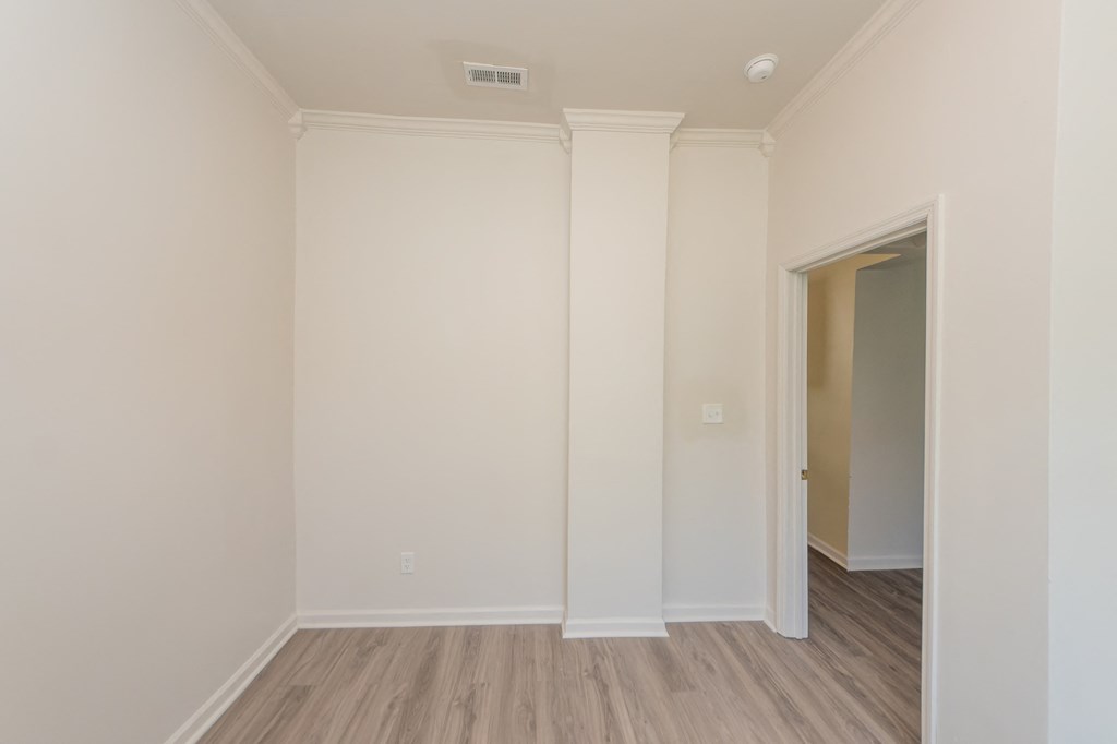 an empty room with white walls and a wooden floor