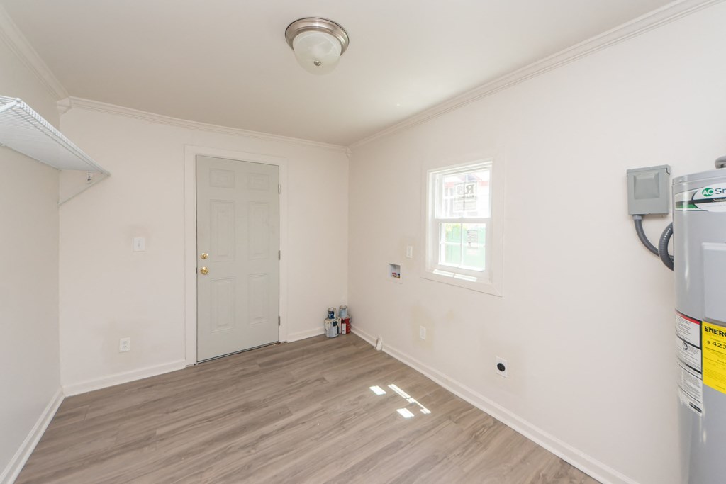 a room with white walls and a white door and a wood floor
