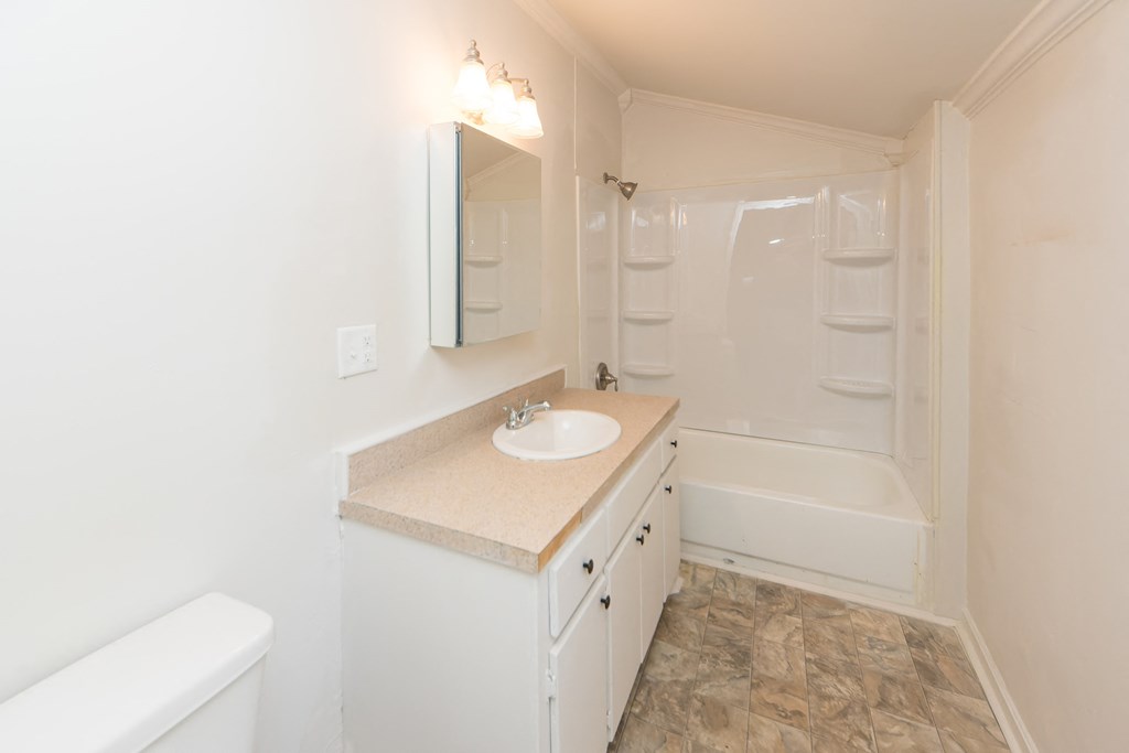 a bathroom with a sink and a shower and a mirror