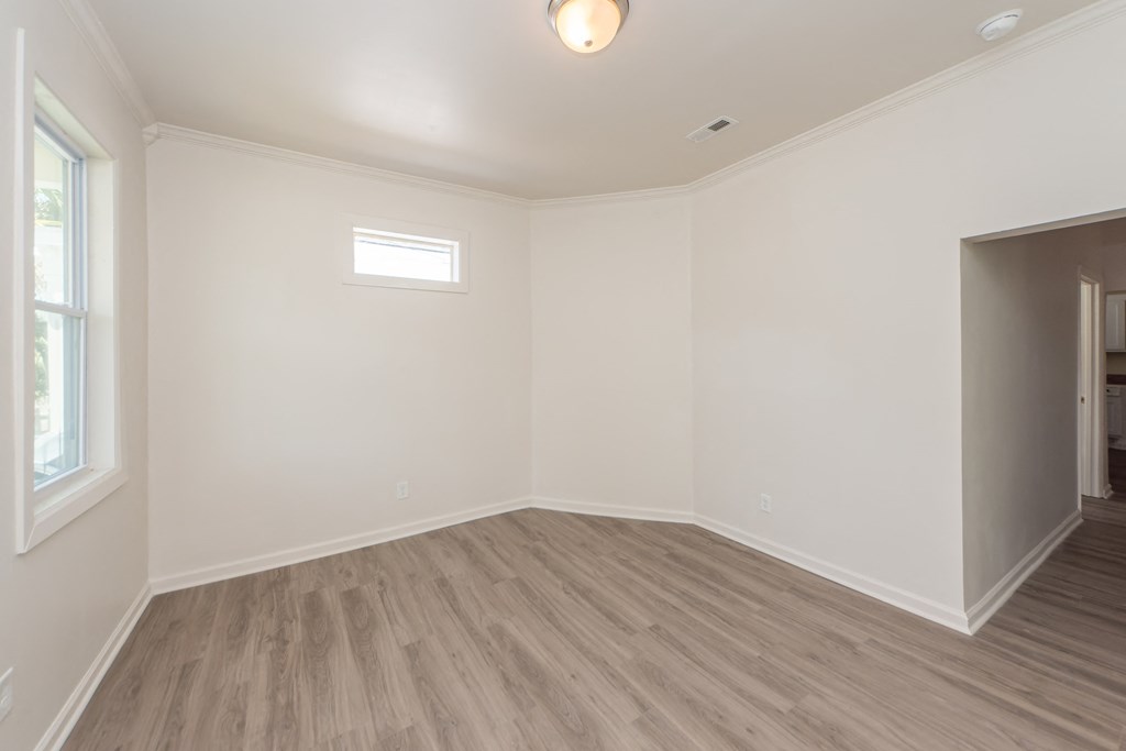 an empty living room with white walls and a window