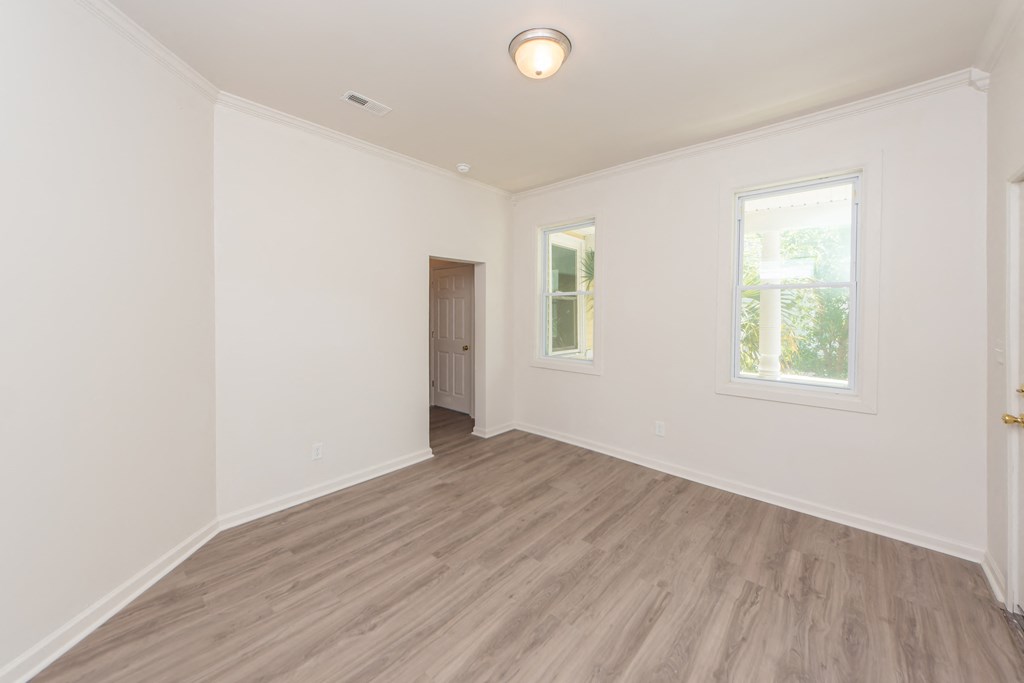 an empty living room with white walls and wood floors