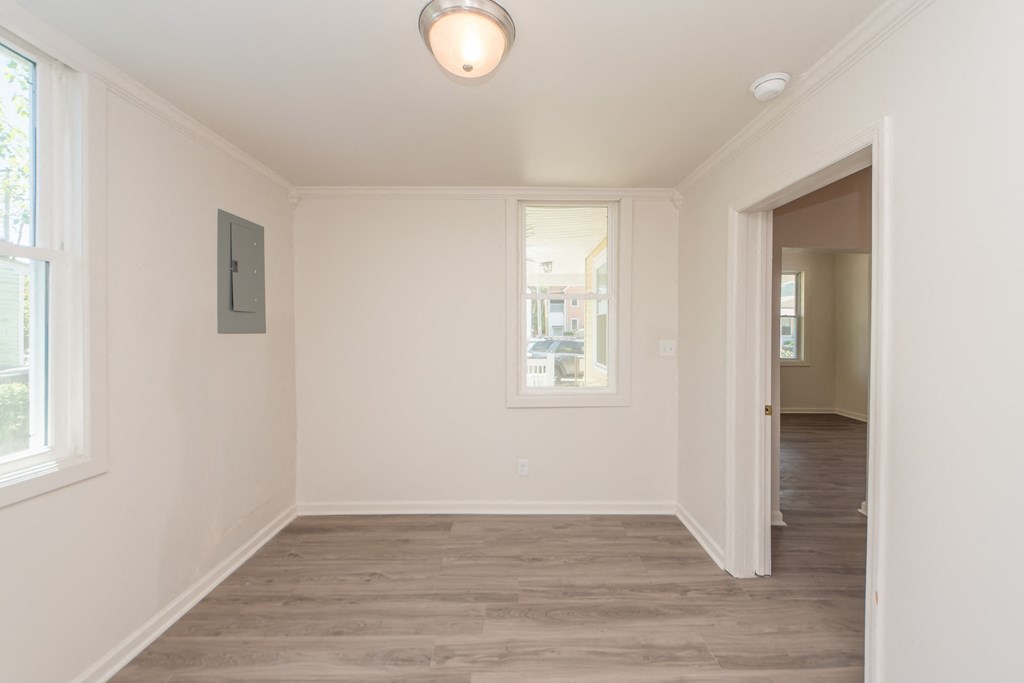 a living room with white walls and a door to a hallway