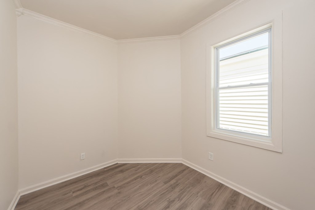 an empty room with white walls and a window