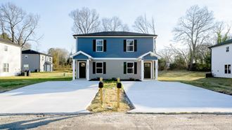 a blue house with a white driveway