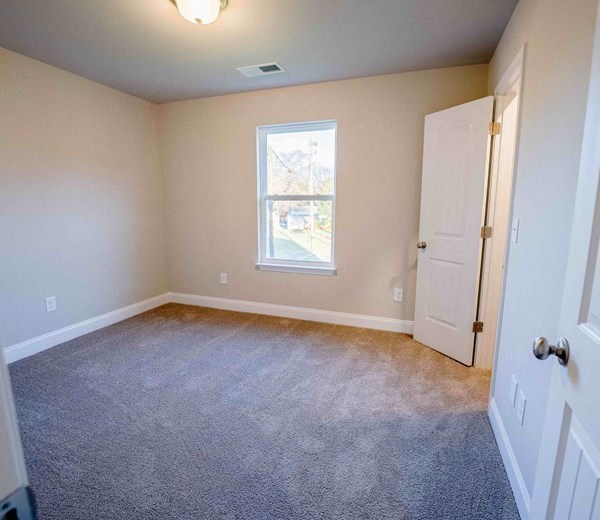 a room with carpet and a window and a door