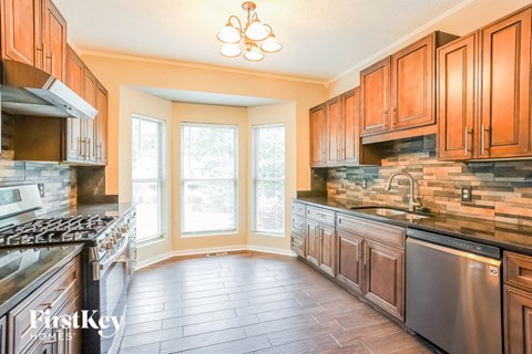 A kitchen with wooden cabinets and a stainless steel dishwasher.