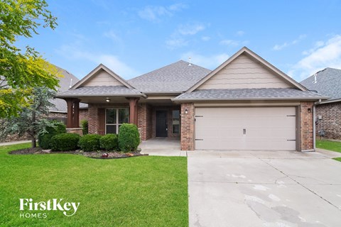 A house with a garage and a driveway in front of it.