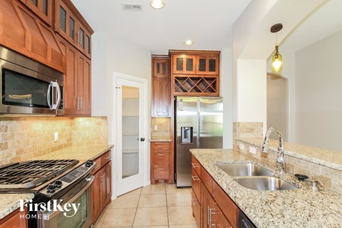 A kitchen with wooden cabinets and a stainless steel refrigerator.