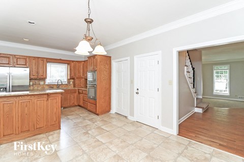 A kitchen with wooden cabinets and a refrigerator.