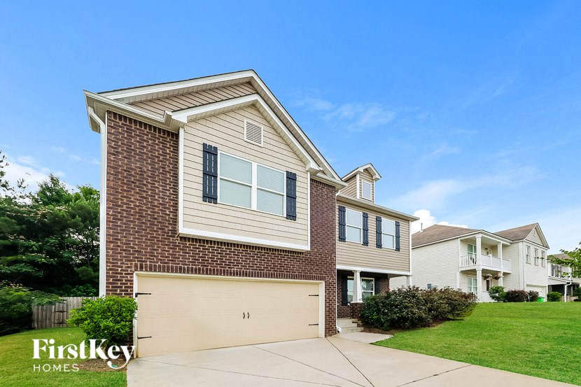 a house with a garage door in front of a lawn