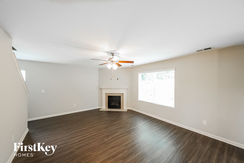 a living room with a ceiling fan and a fireplace