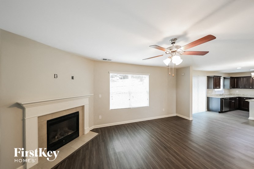 a living room with a fireplace and a ceiling fan