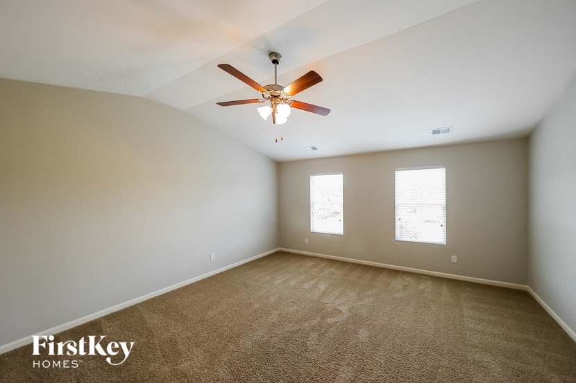 an empty room with a ceiling fan and a window