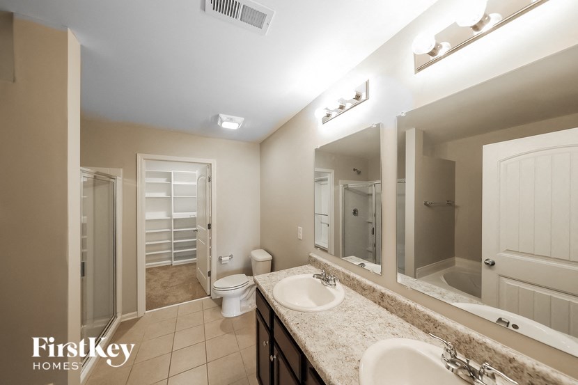 a bathroom with two sinks and a toilet and a mirror