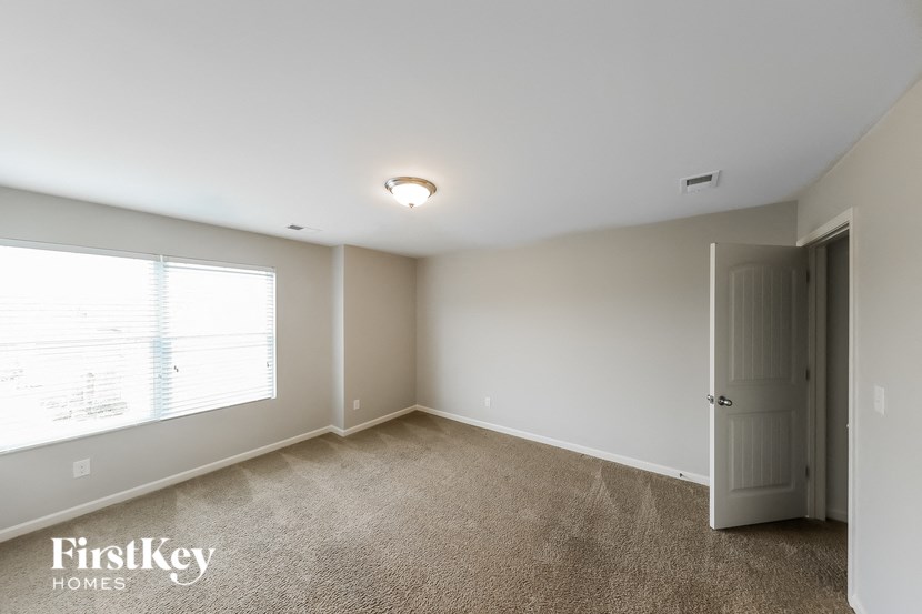 a bedroom with a large window and a door to a closet