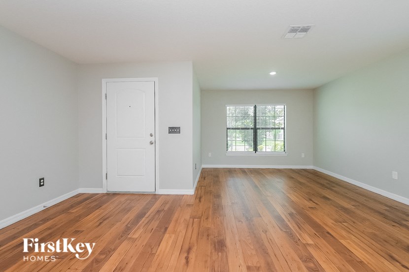 the master bedroom with hardwood flooring and a white door