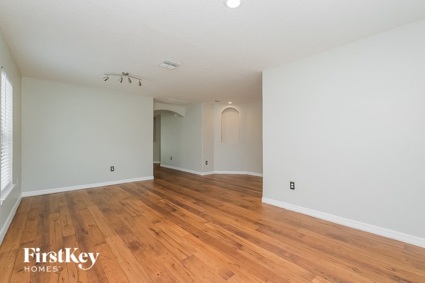 the living room and dining room with wood floors and white walls