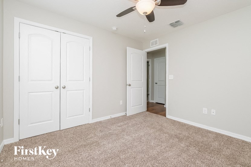 a bedroom with two closets and a ceiling fan