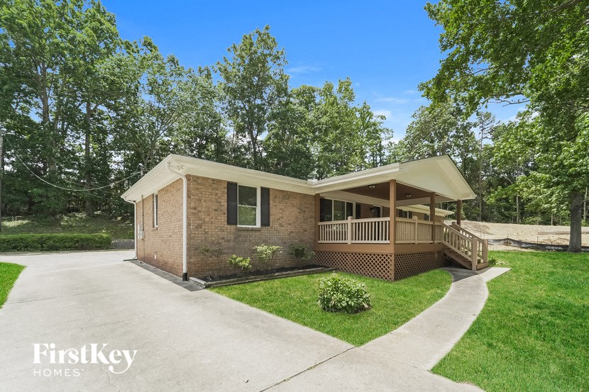 a small brick house with a porch and a sidewalk