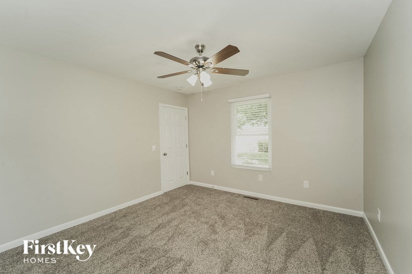 an empty room with a ceiling fan and a white door
