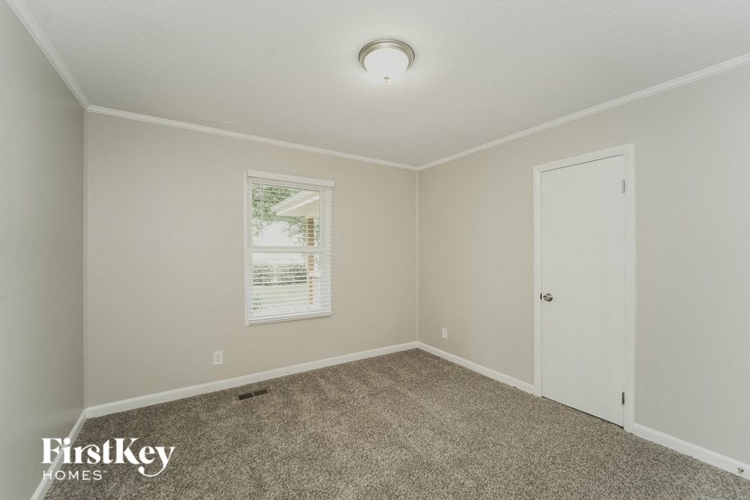 an empty room with carpet and a white door