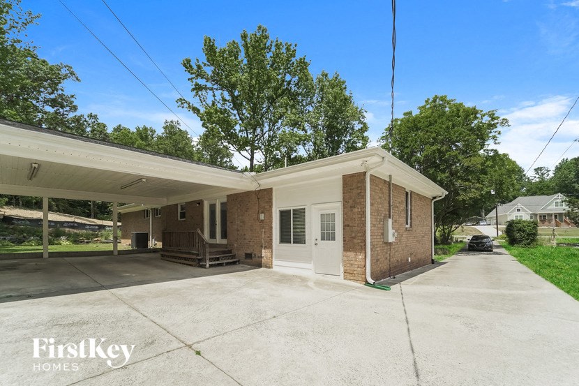 a brick house with a large driveway and a white roof