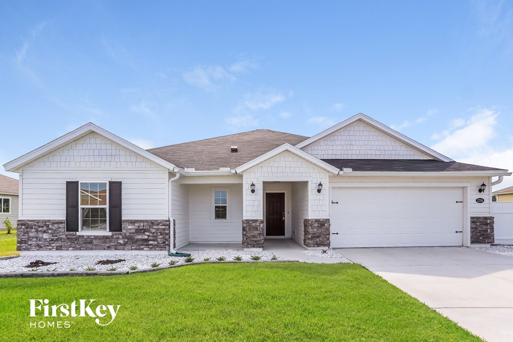 a white house with a lawn and a driveway