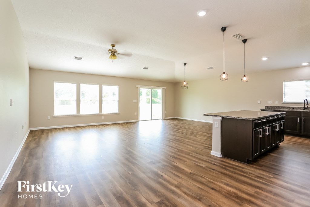 an empty kitchen and living room with hardwood flooring