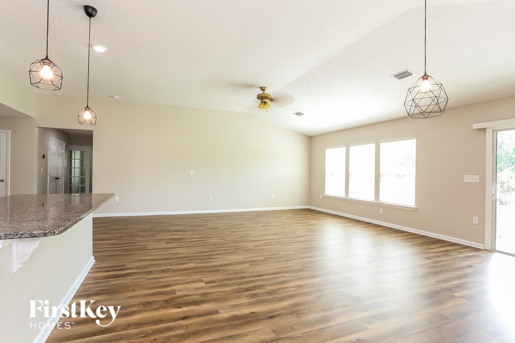 the living room and dining room with a large window and wood flooring