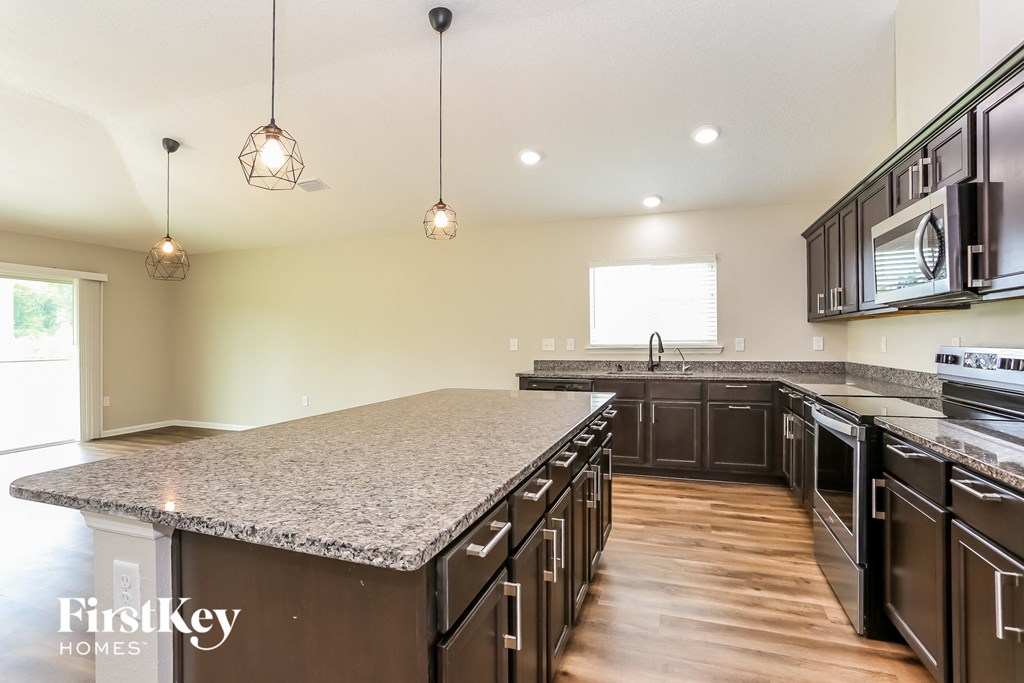 a kitchen with granite counter tops and dark wood cabinets