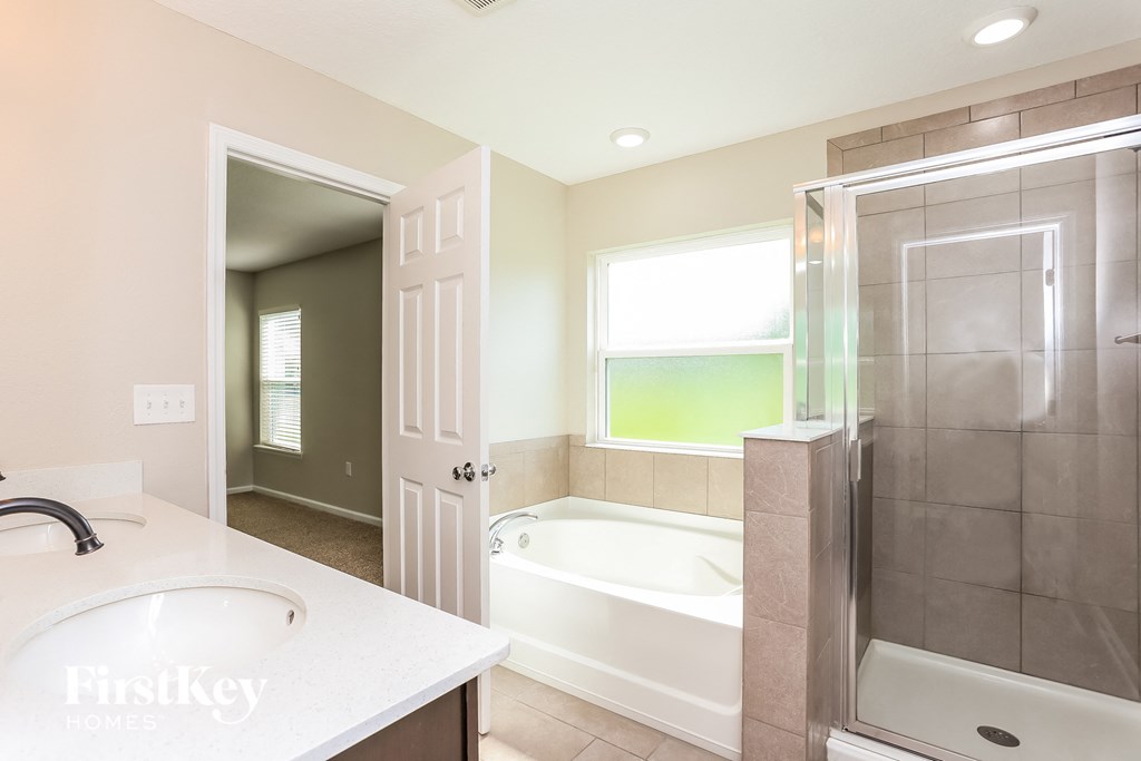 a bathroom with a tub and a sink and a shower
