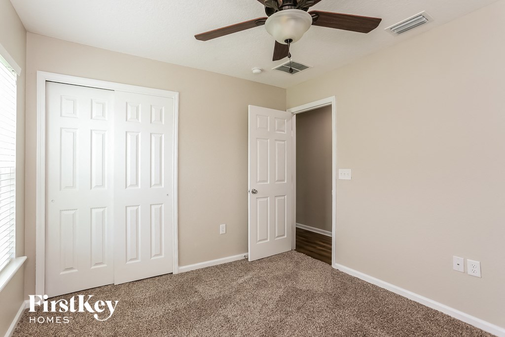 a bedroom with two closets and a ceiling fan