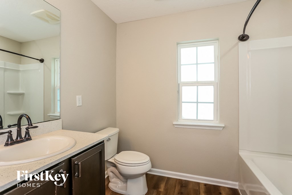 a bathroom with a toilet and a sink and a shower