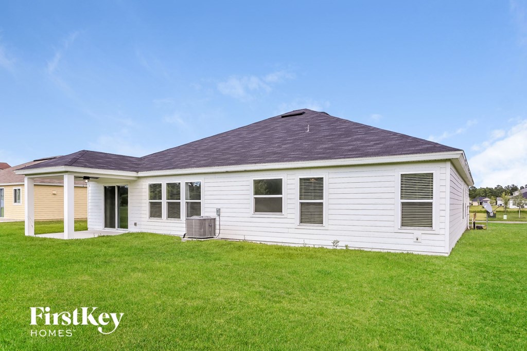 a white house with a gray roof on a green lawn