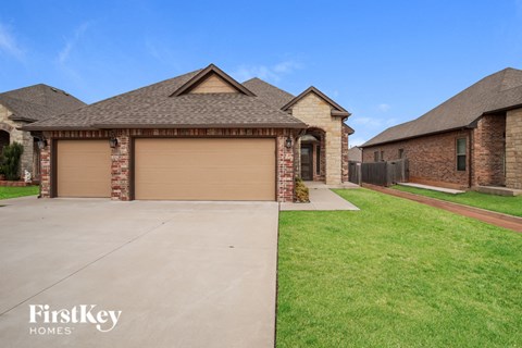 A house with a brown garage door and a brick pillar.