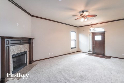 A spacious room with a fireplace and a ceiling fan.