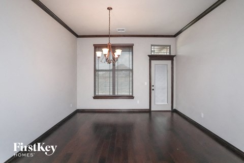 A room with wooden floors and a chandelier.