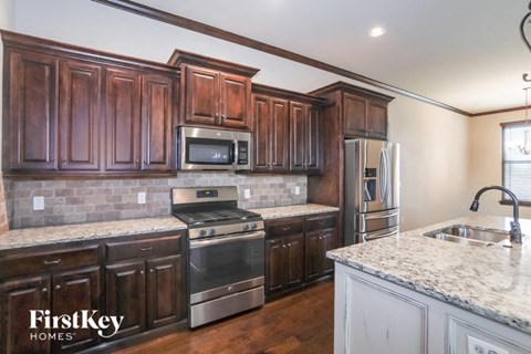 A kitchen with wooden cabinets and a granite countertop.