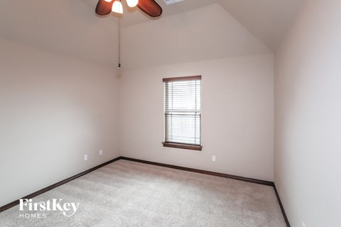 A room with a window and a carpet on the floor.