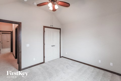 A room with a ceiling fan and two doors.