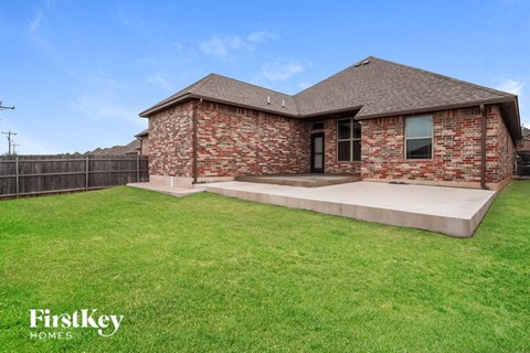 A brick house with a green lawn in front.