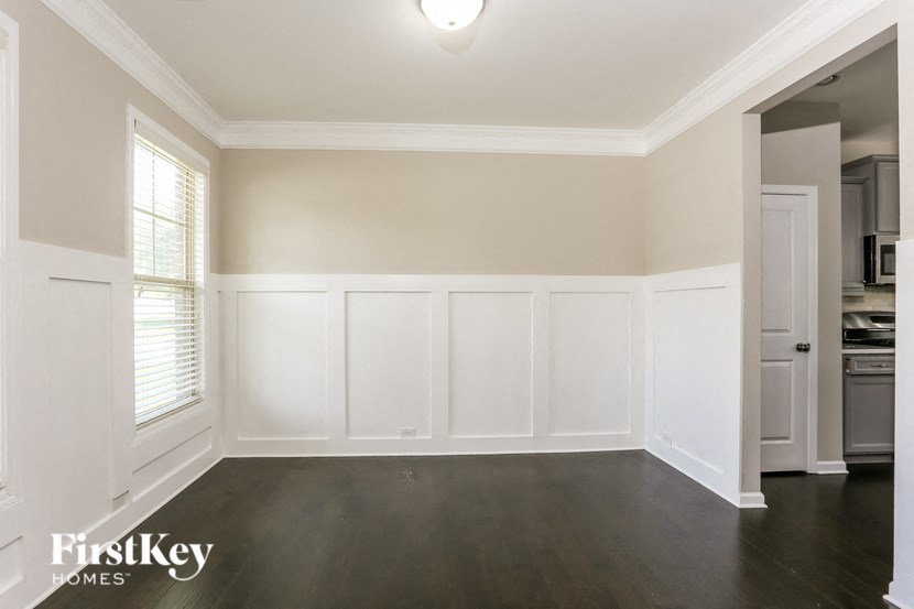 an empty living room with white walls and a dark wood floor