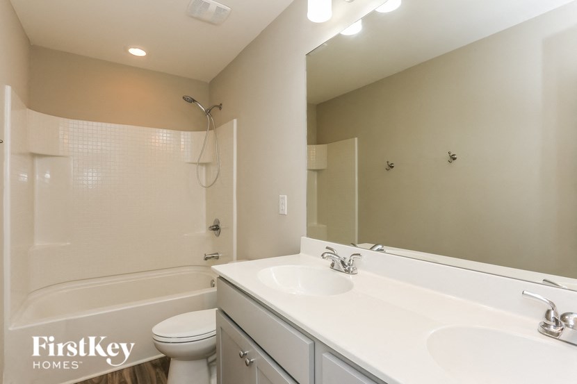 a bathroom with a large mirror and a sink and a toilet
