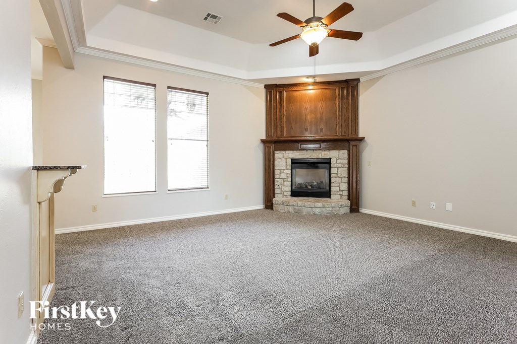 a living room with a fireplace and a ceiling fan