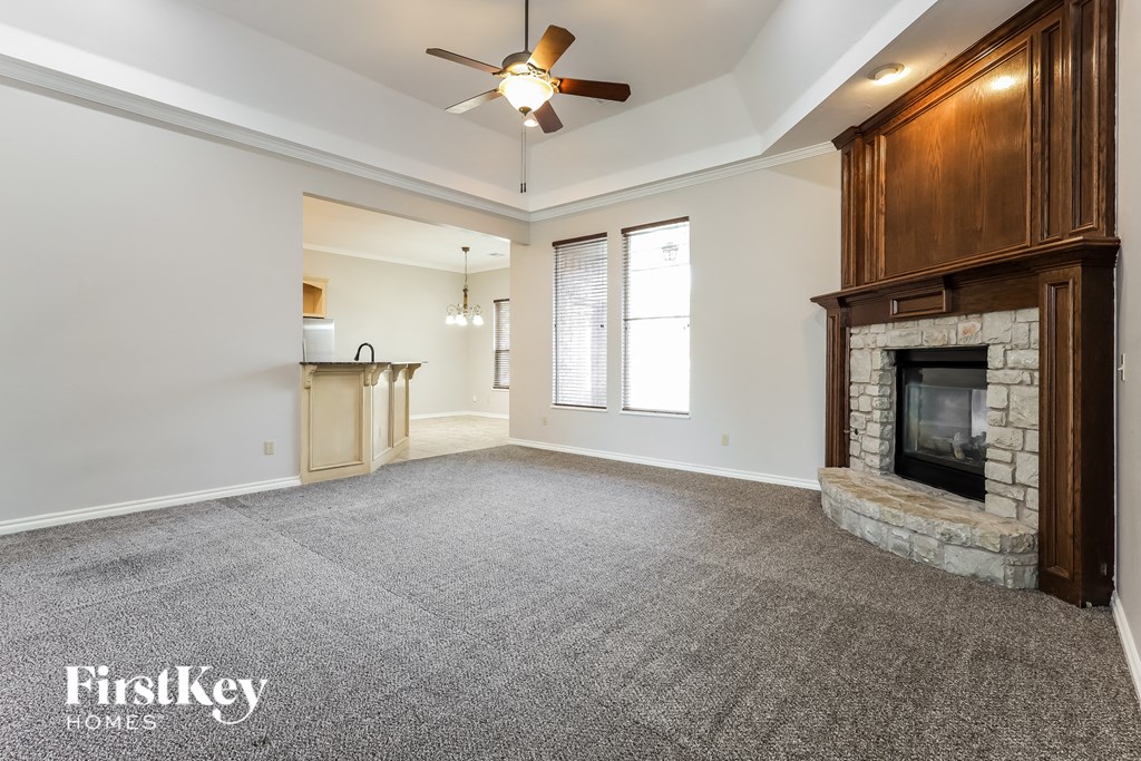 a living room with a fireplace and a ceiling fan