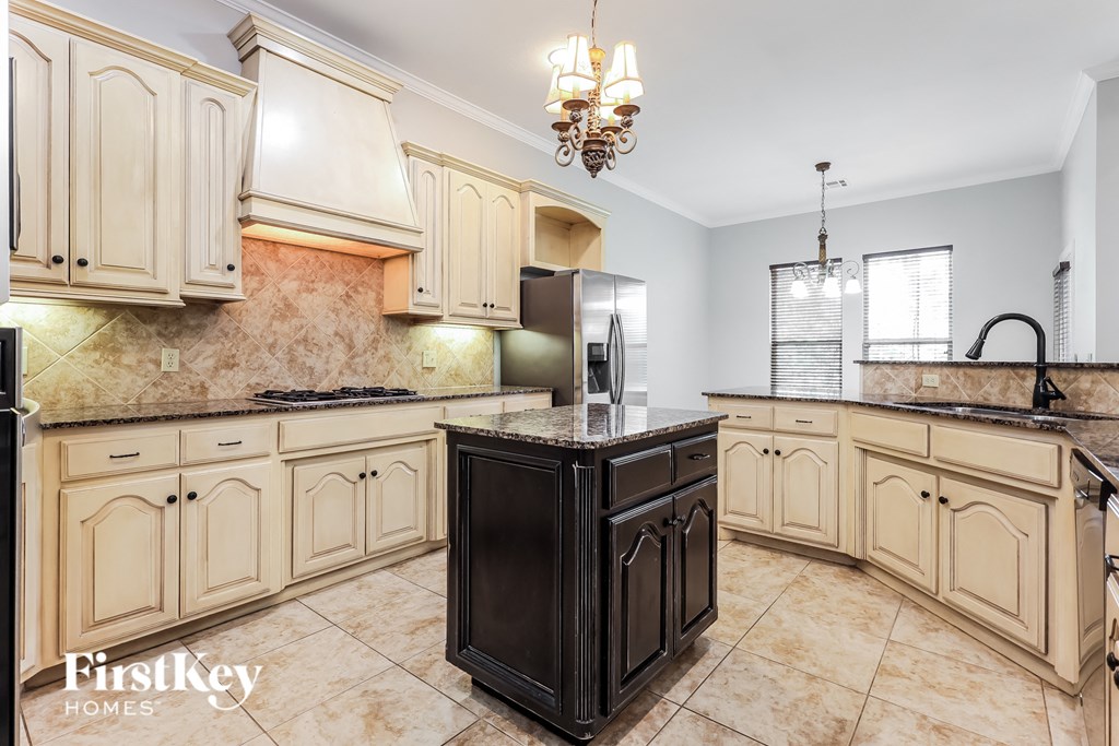 a kitchen with white cabinets and a black center island