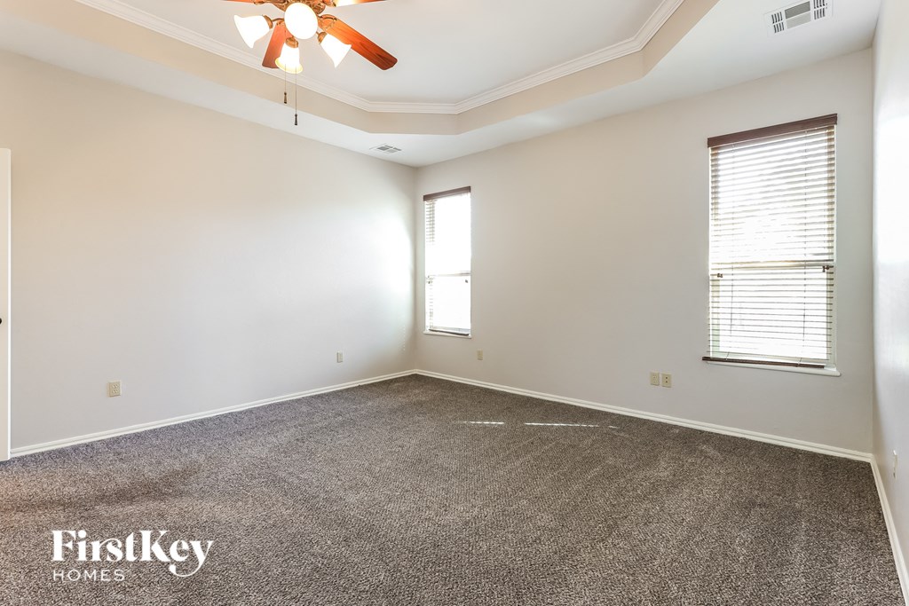 the spacious living room with carpeting and a ceiling fan