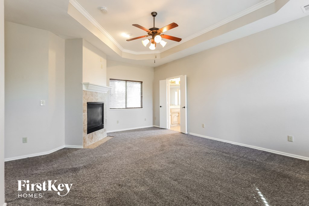 a living room with a fireplace and a ceiling fan