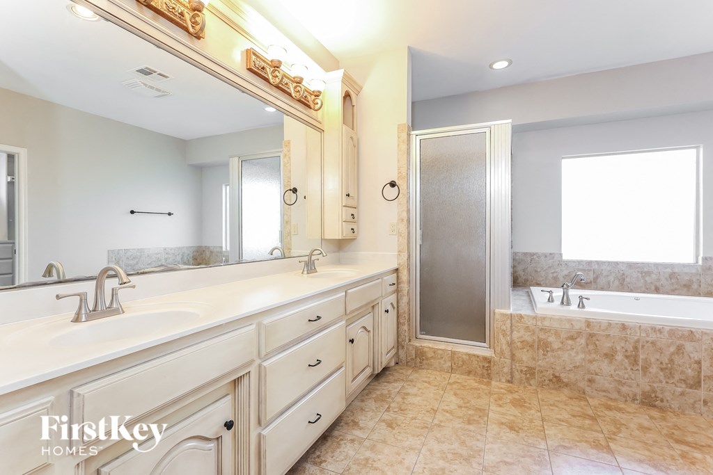 a large bathroom with two sinks and a tub and a shower