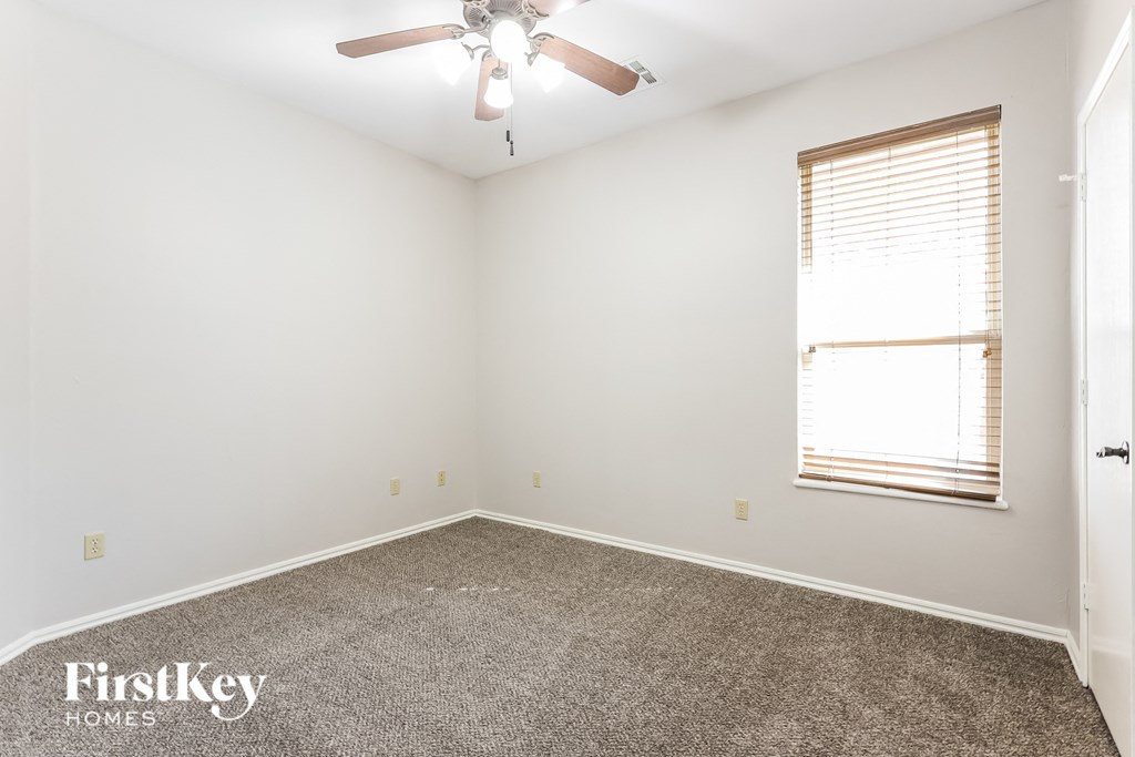 a bedroom with a ceiling fan and a window